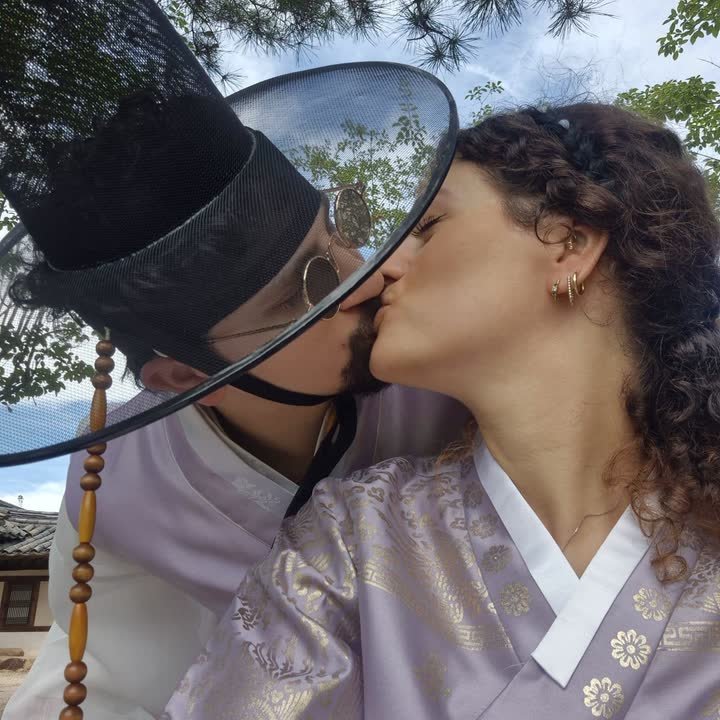 Dorah et Oscar s'embrassent, vêtus de hanboks traditionnels